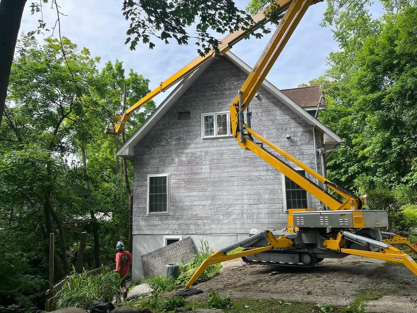 A yellow crane is sitting in front of a house.