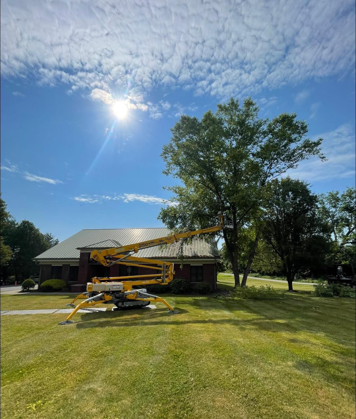 A yellow crane is sitting in front of a house.