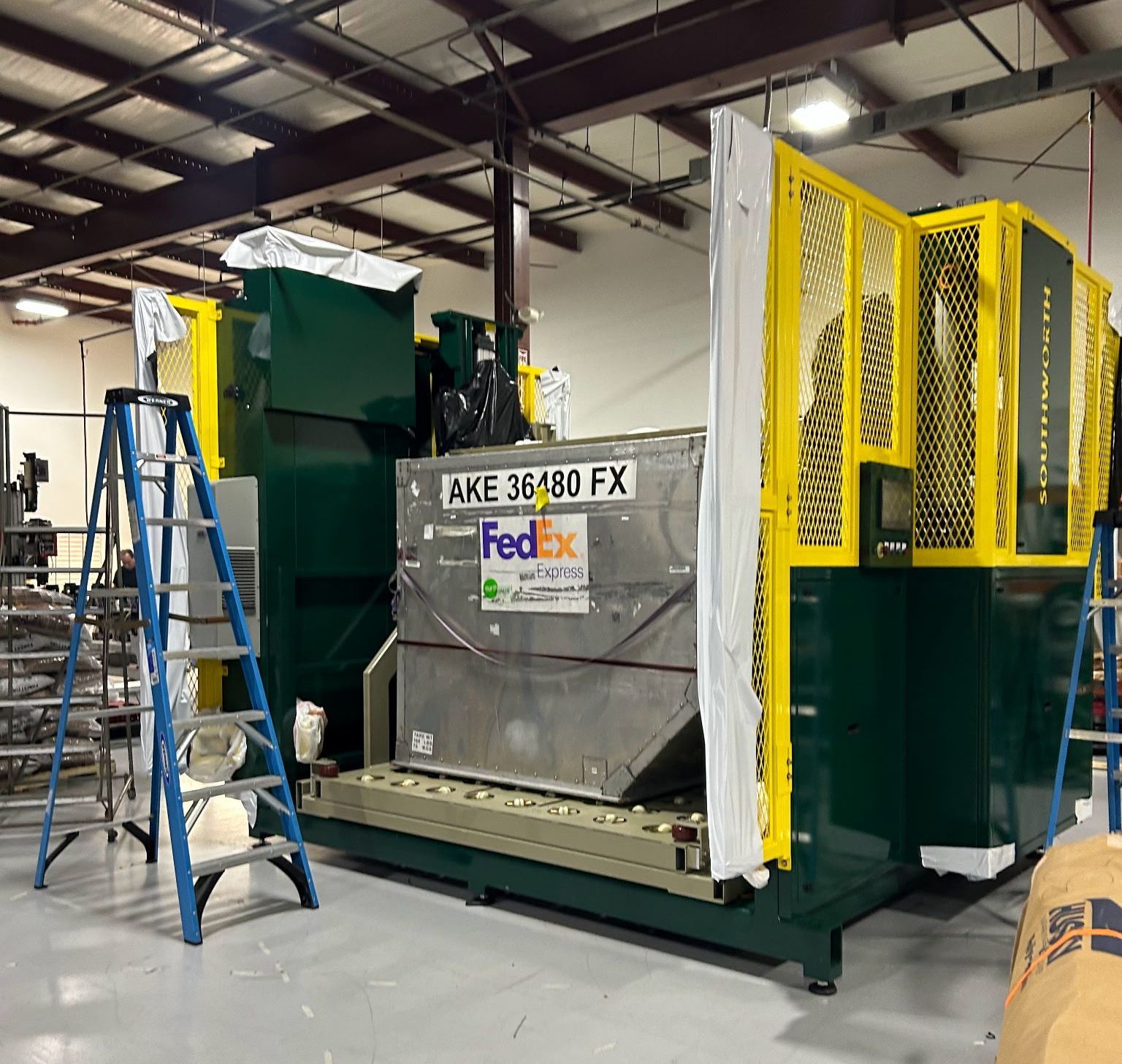 A machine is sitting on top of a cart in a factory.