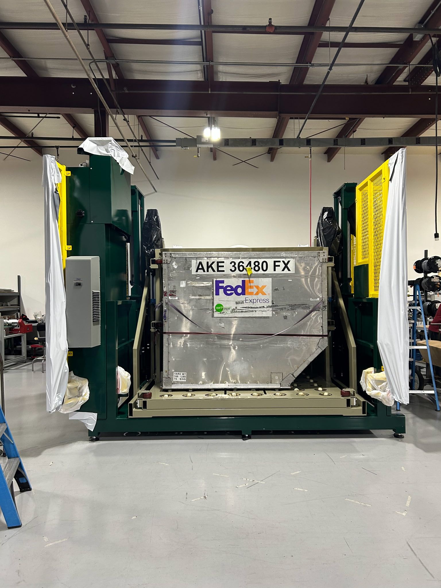 A large fedex machine is sitting in a warehouse.
