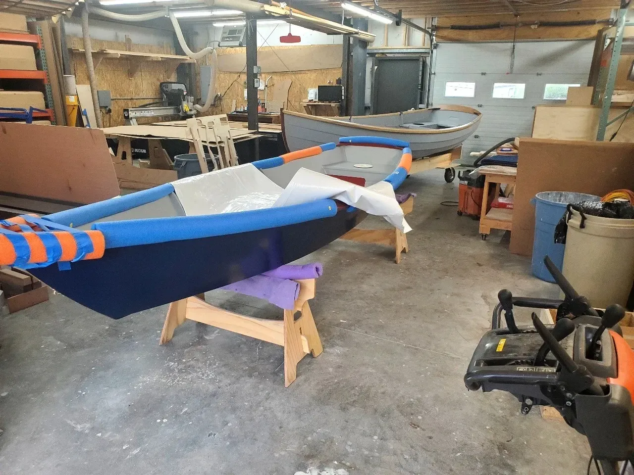 A boat is sitting on a wooden stand in a garage.