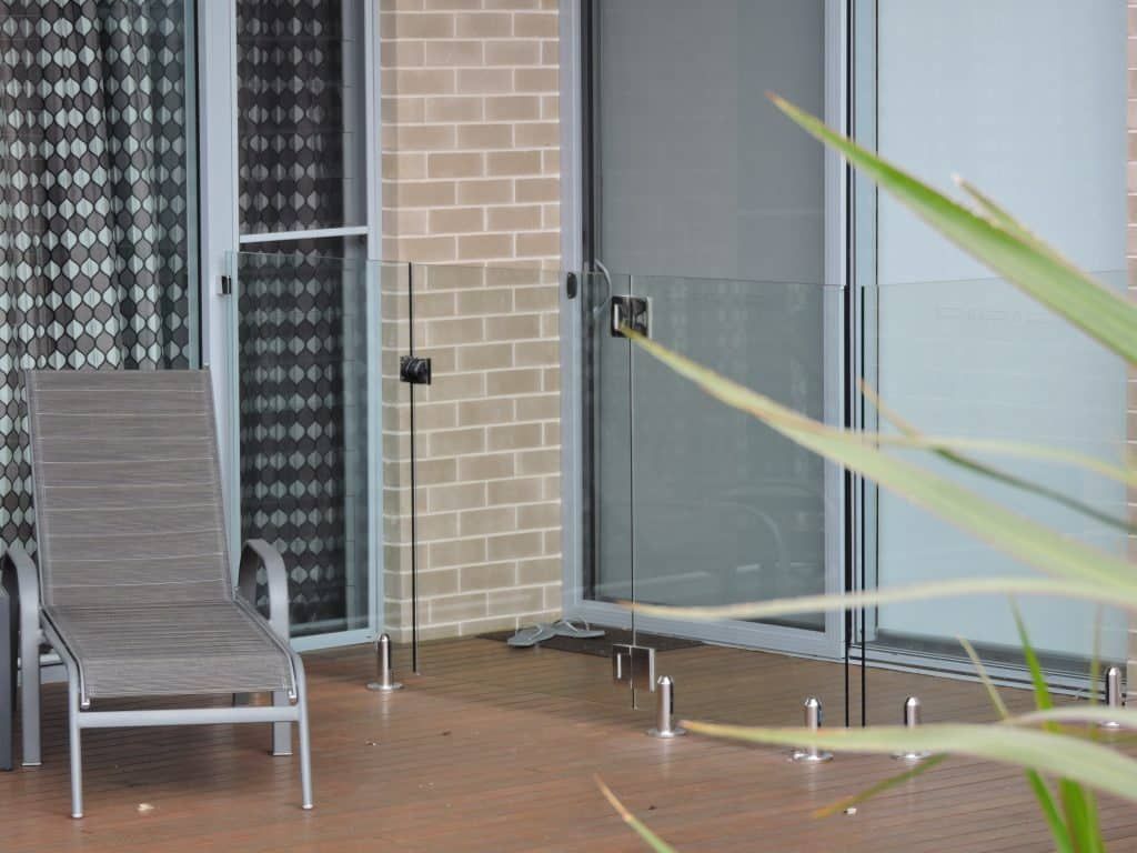 Lounge Chair Sits Next To A Sliding Glass Door - Frameless Balustrade in Newcastle, NSW