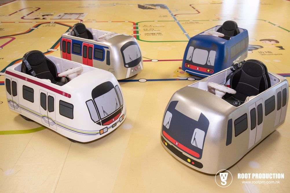 Four toy train cars in different colors on a map-like surface.