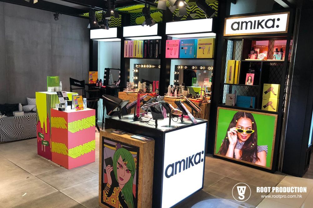 Amika beauty store interior with colorful product displays and backlit signage featuring artwork and models.