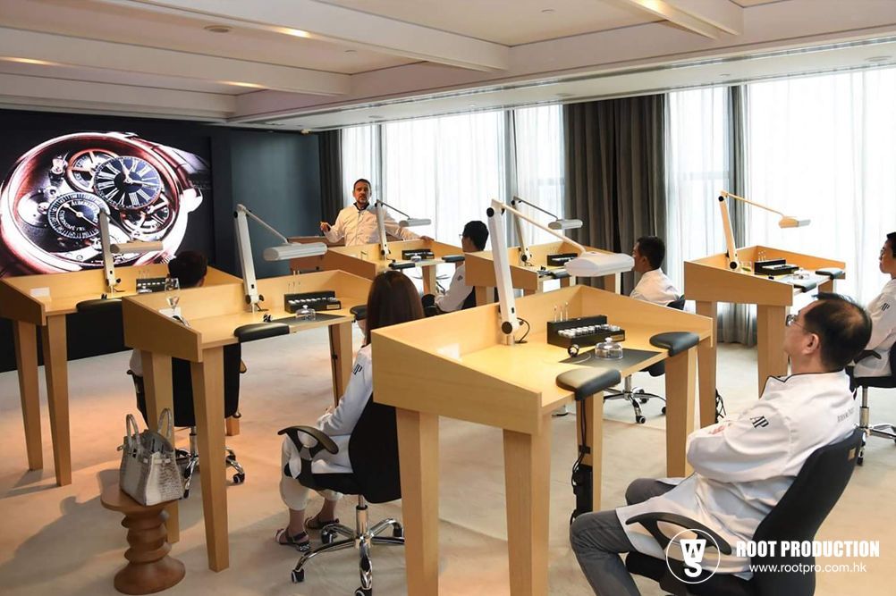A watchmaking class with students at individual work stations; instructor lecturing.