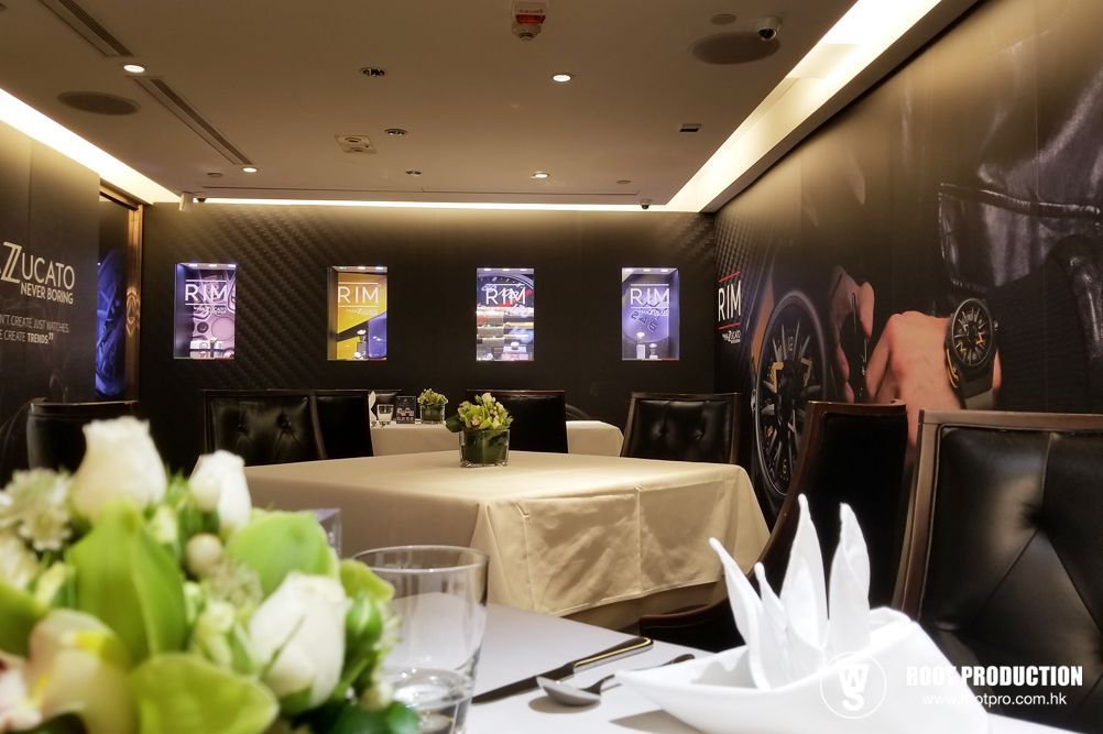 Formal dining area with square table, black chairs, posters, and flower arrangements.