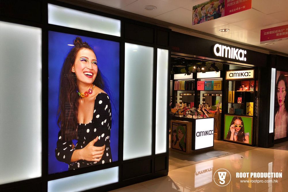 Amika beauty store entrance with a smiling woman in a polka-dot top, blue background.