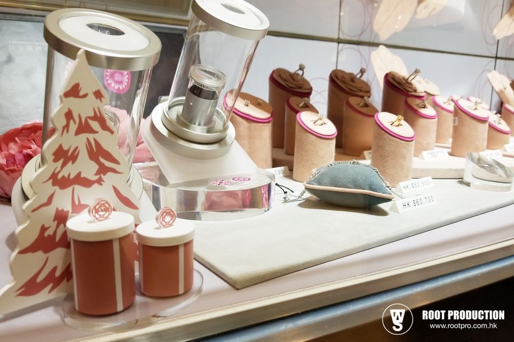 Jewelry display with rings, decorative trees, and gift boxes in a shop window.