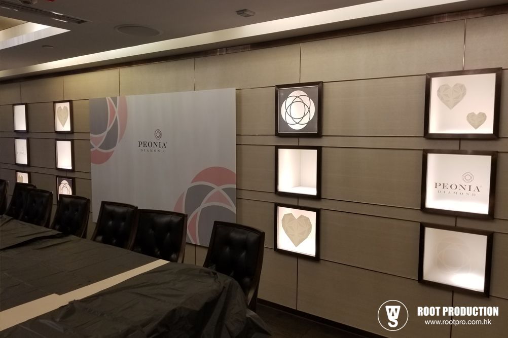 Jewelry store conference room with illuminated display cases, logo, and long table.
