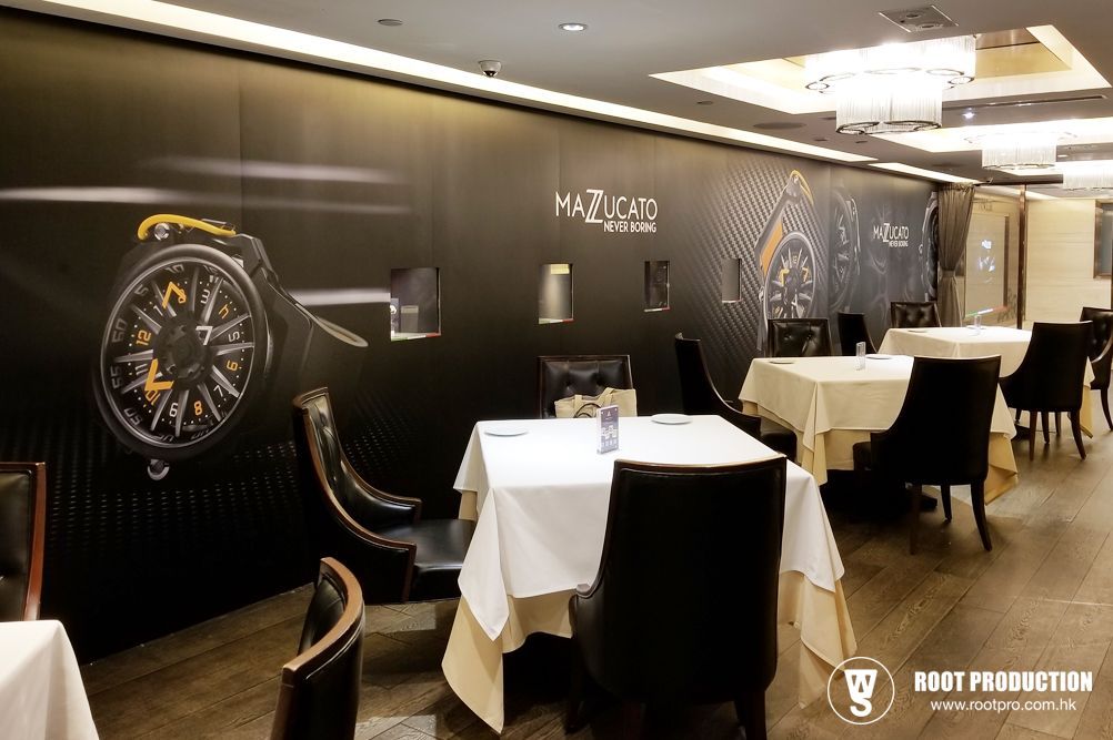 Restaurant interior with tables, chairs, and watch advertisement on the wall.