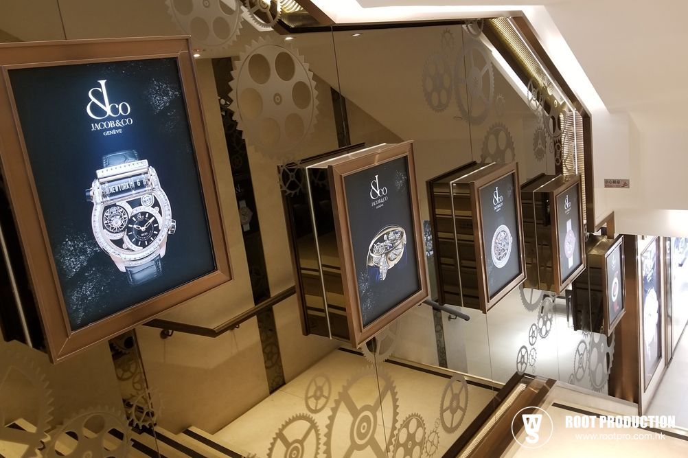 Display cases with watch advertisements along a staircase, featuring a steampunk aesthetic.