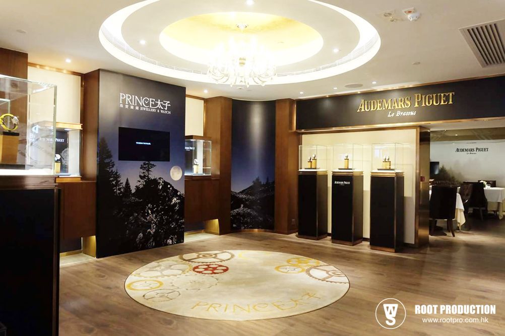 Interior of a luxury watch store. Display cases, a carpet, and a chandelier.