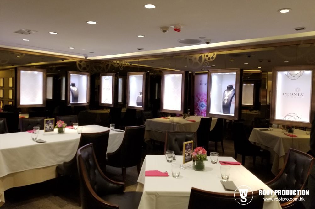 Interior of a restaurant with tables set for dining, jewelry displays along walls.