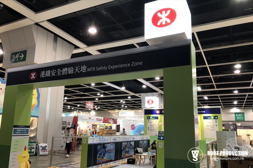 Entrance archway to a MTR virtual experience zone at a convention hall. Green and white signage, with a red MTR logo.