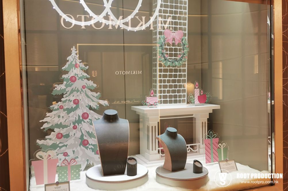 Mikimoto jewelry store window display, Christmas theme with jewelry, tree, fireplace, and gifts.