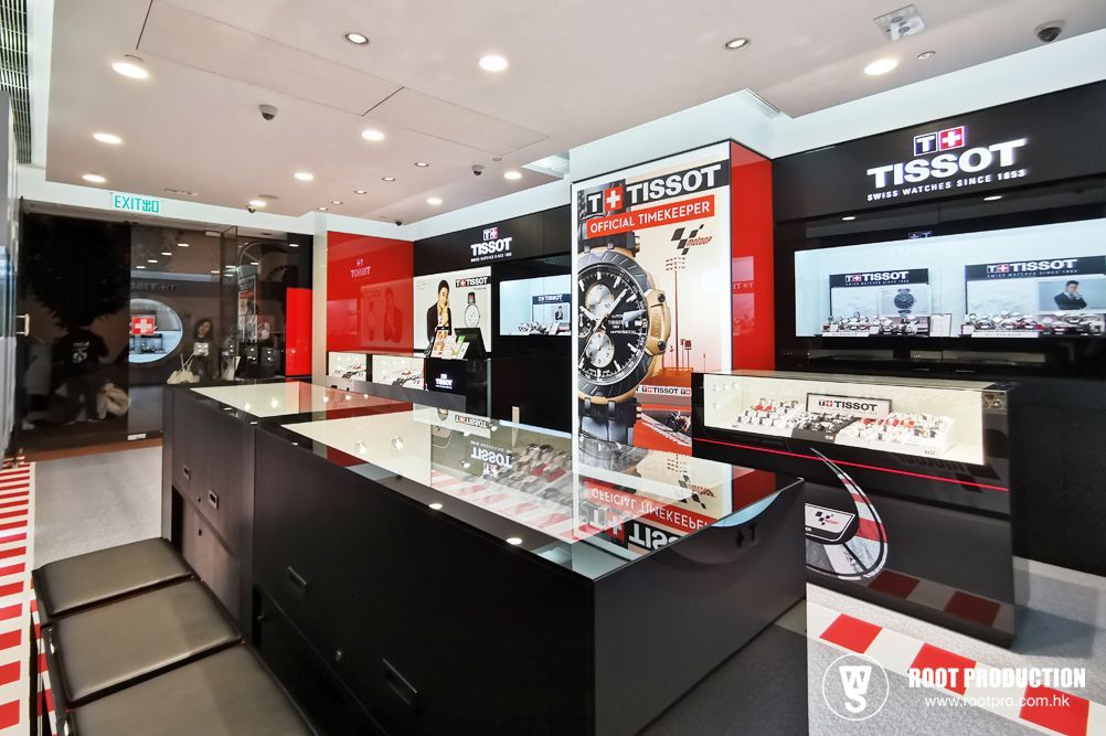 Interior of a Tissot watch store. Displays, watches, red/black decor, and a glass counter are visible.