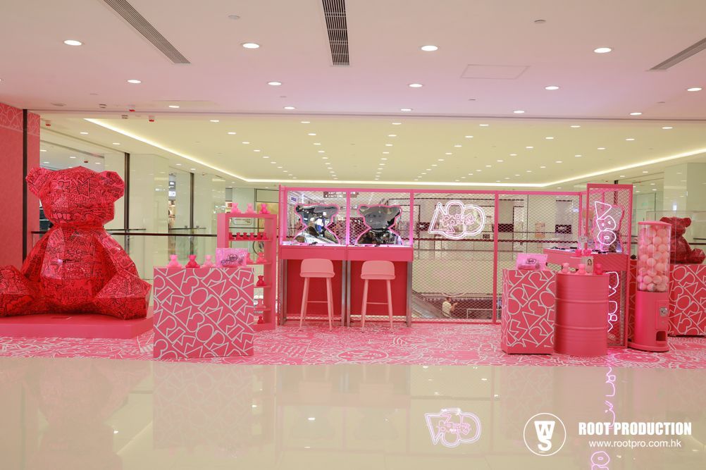 Pink mall display with bear statue and product showcases.