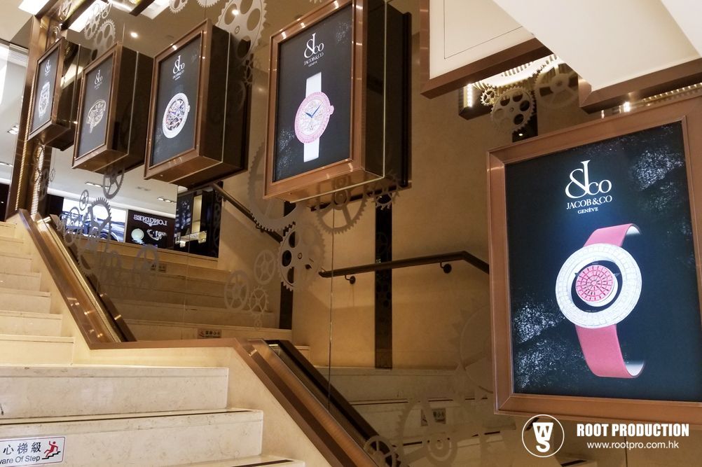 Staircase with watch advertisements, steampunk decor. Bronze frames, watch displays in a building.