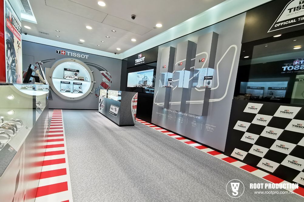 Tissot watch store interior with racing theme; red and white stripes on floor, watches displayed.