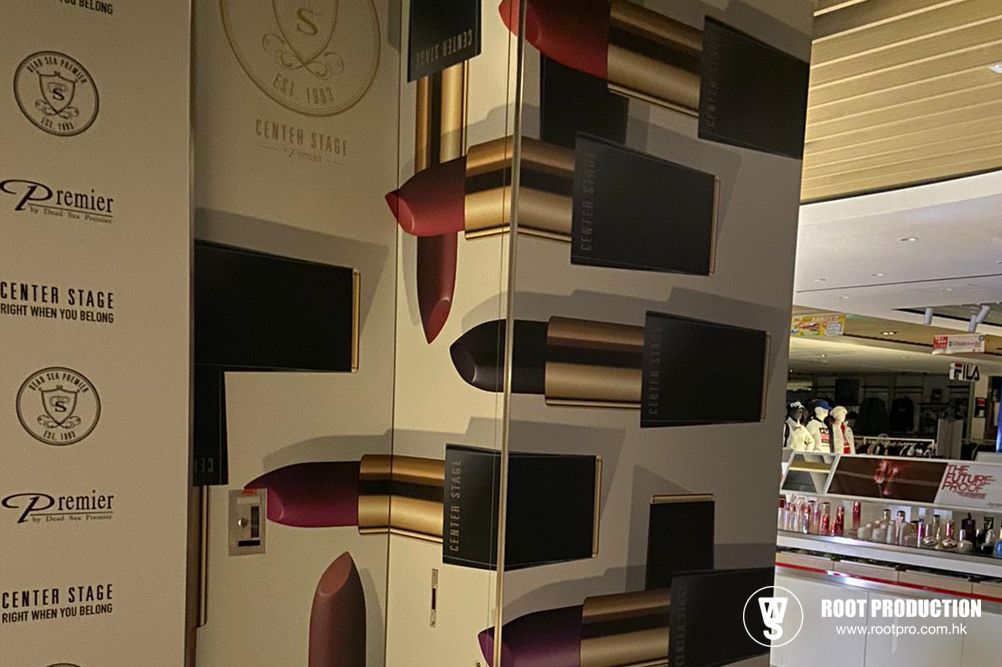 Cosmetics display with lipstick tubes, gold packaging, and product branding at a retail store.