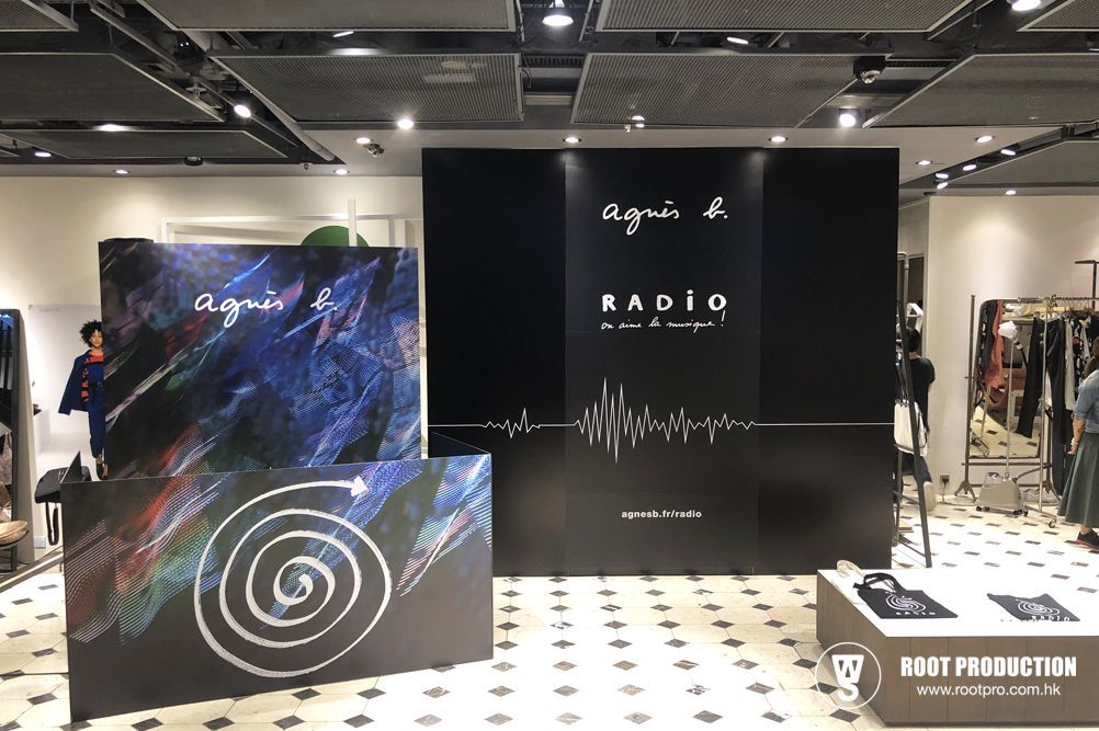 A retail store display for Agnes B. with a black backdrop, the word 