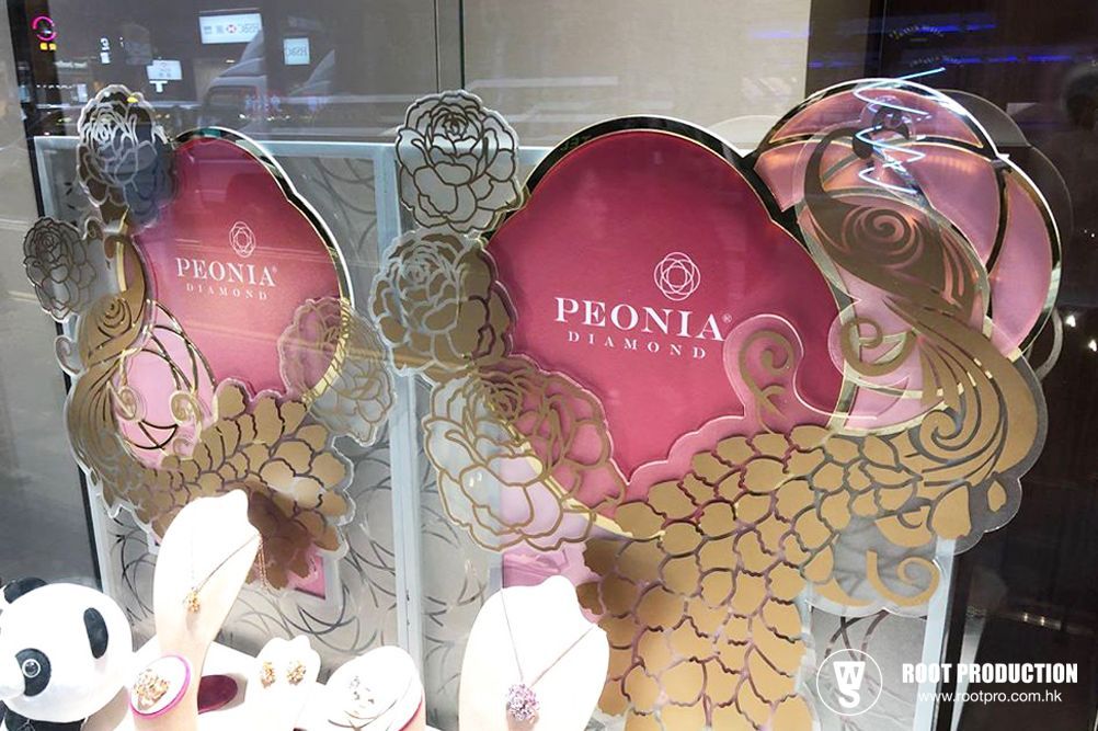 Jewelry display with pink peony-themed background and gold accents.