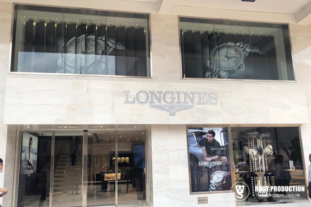 Exterior of a Longines watch store with large window displays. Marble facade, logo above entrance.
