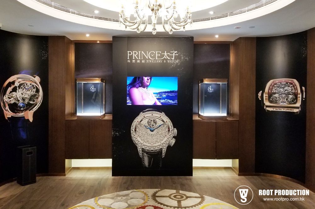 Luxury watch store interior with displays, video screen, and chandelier.