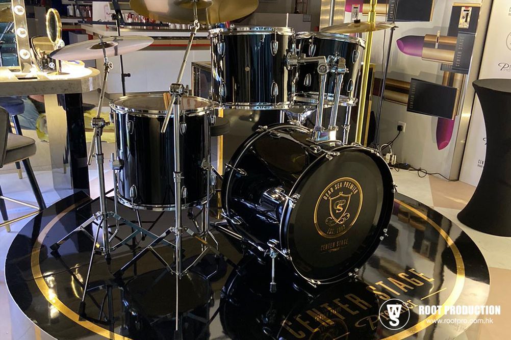 Black drum kit set up on a black and gold floor in a store.
