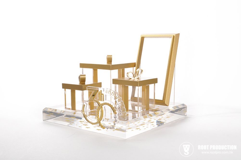 Jewelry display with gold and clear acrylic elements, showcasing rings and earrings against a white background.