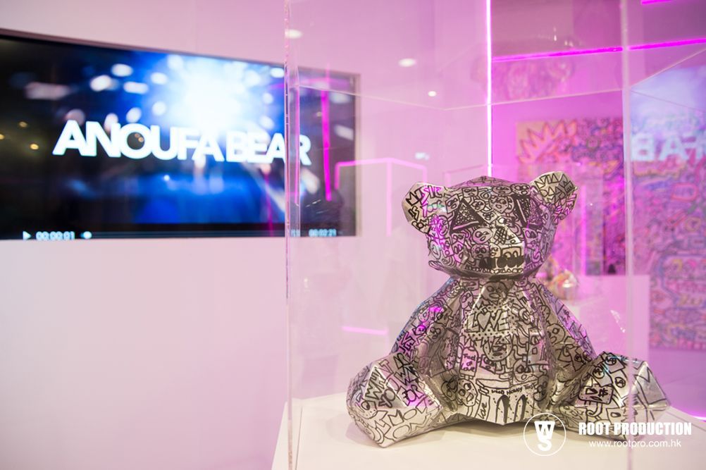 A metallic bear sculpture in a display case. The word 