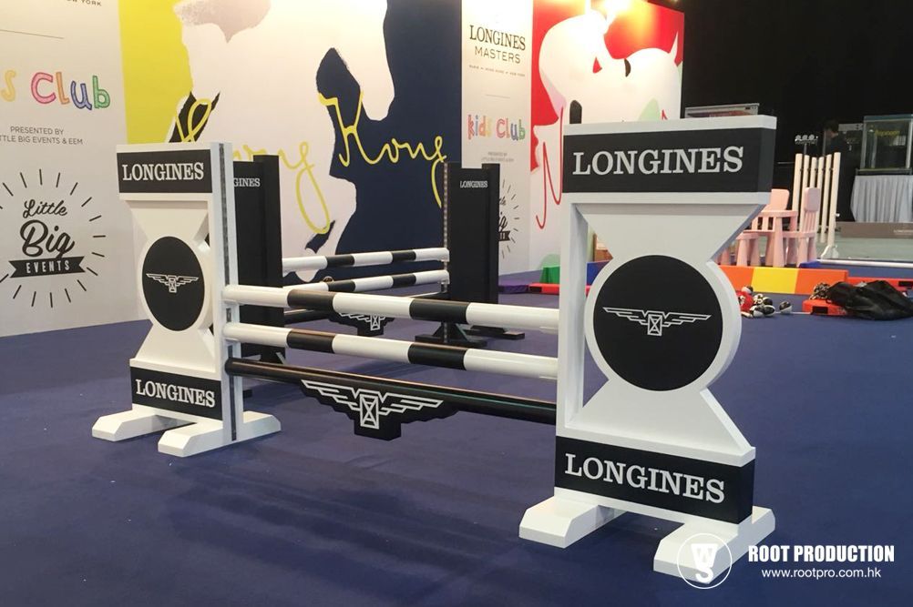 White and black Longines horse jumping obstacle at an event.