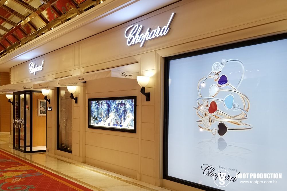 Chopard luxury jewelry store front with display of bracelets, soft lighting, and an entrance.