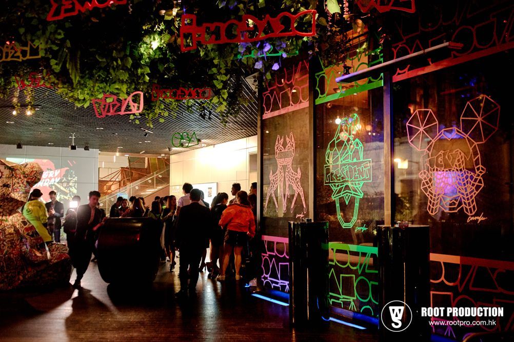 People gather in a modern art gallery with colorful neon art and decor.