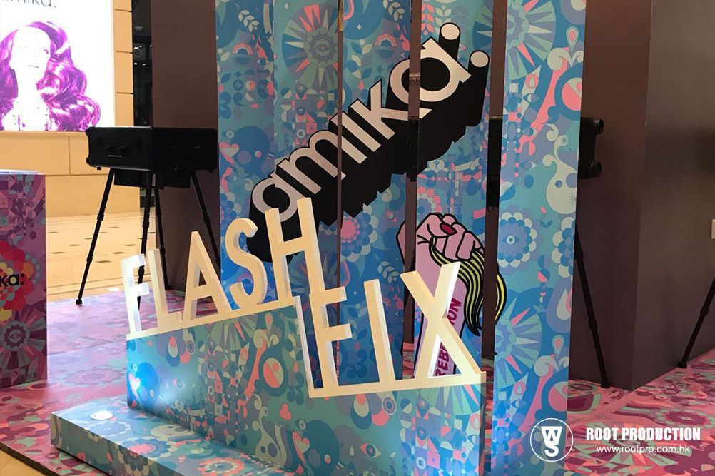 Amika Flash Helix sign, colorful display, blue and pink, with hand and logo.