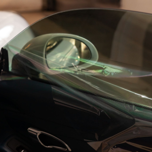 Close-up of a cracked car side window with a dark tint, seen from inside the vehicle.
