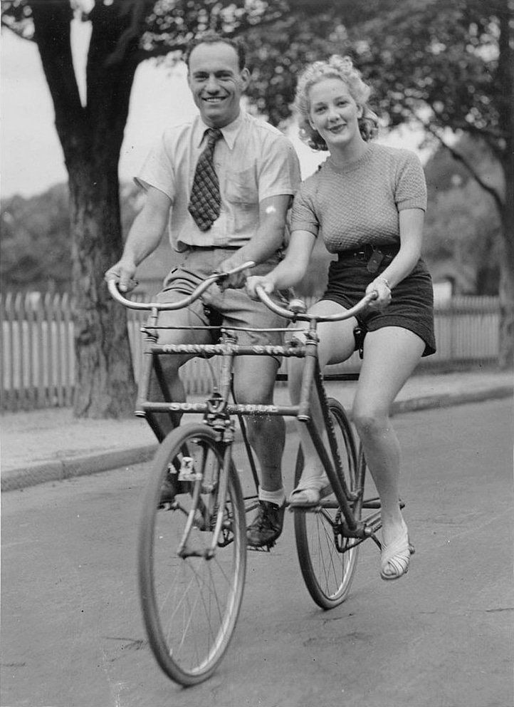 Tandem, auf dem eine Frau und ein Mann nebeneinander sitzen