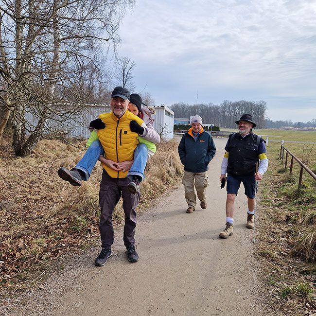Foto. Jo W. hat jemanden (schlecht sichtbar) auf dem Rücken genommen.