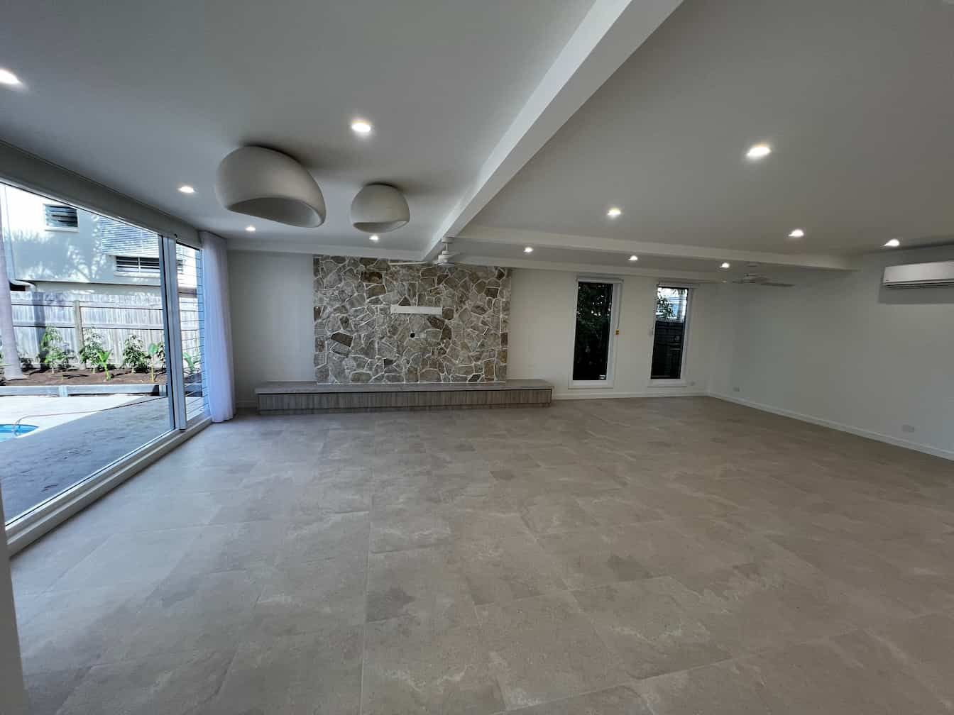 An Empty Room With a Fireplace and a Large Window — Poljak Plasterers in Kirwan, QLD