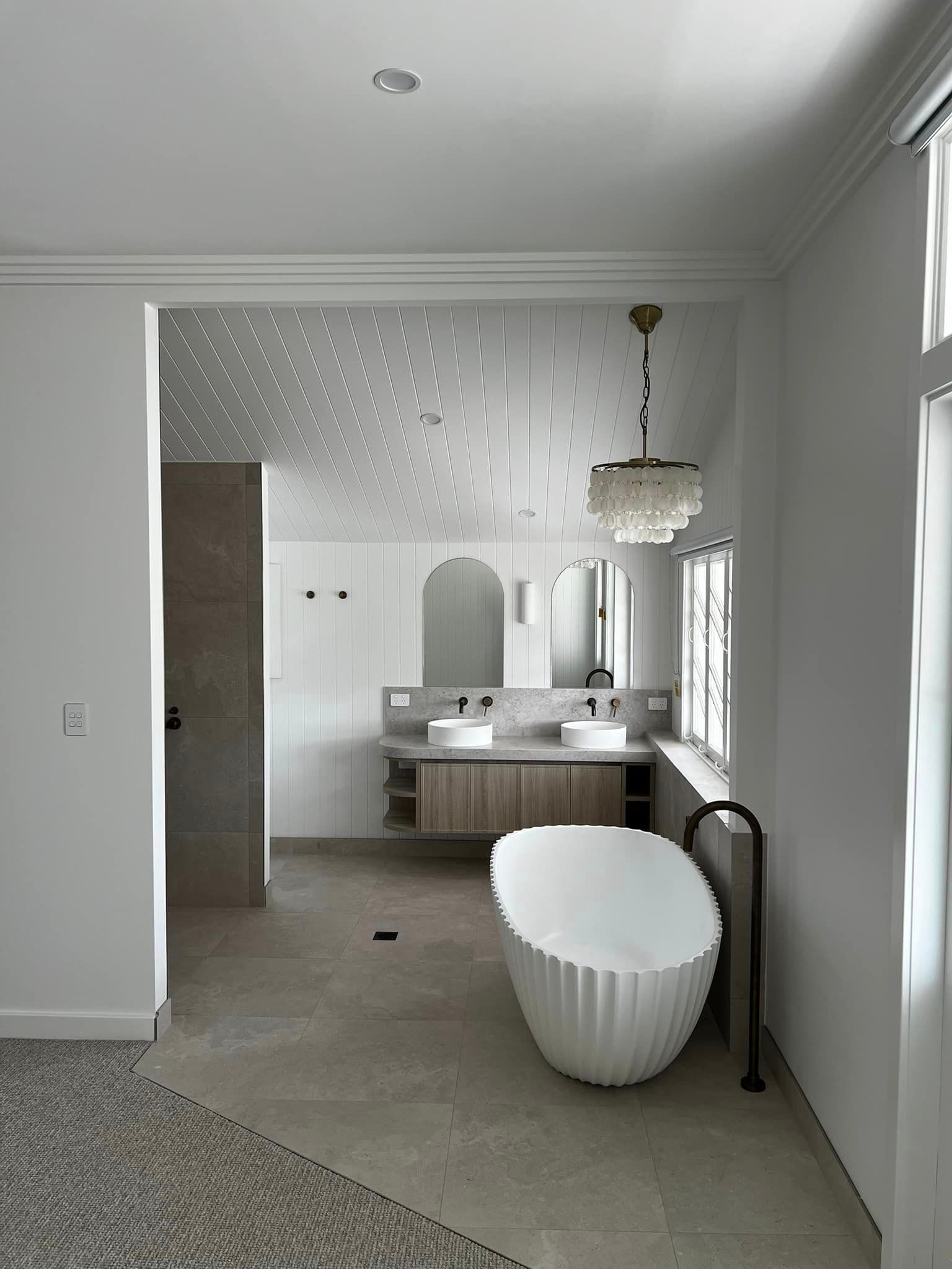 A Bathroom With a Bathtub, Sinks, Mirrors and a Window — Poljak Plasterers in North Ward, QLD