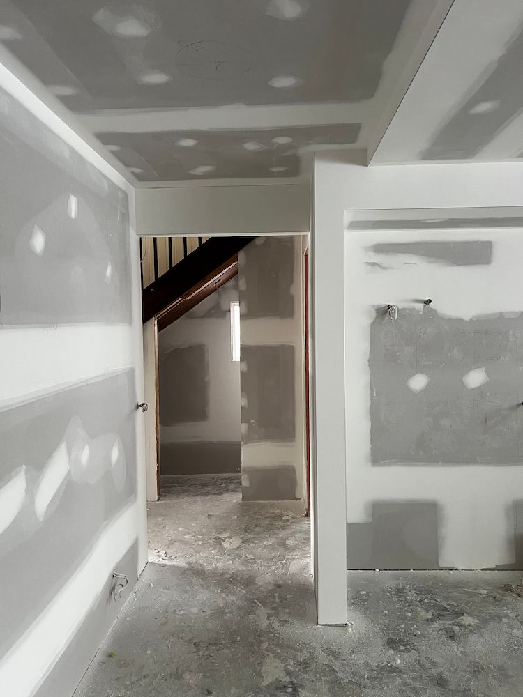 An Empty Room With Drywall Walls and a Staircase in the Background — Poljak Plasterers in Mount Louisa, QLD