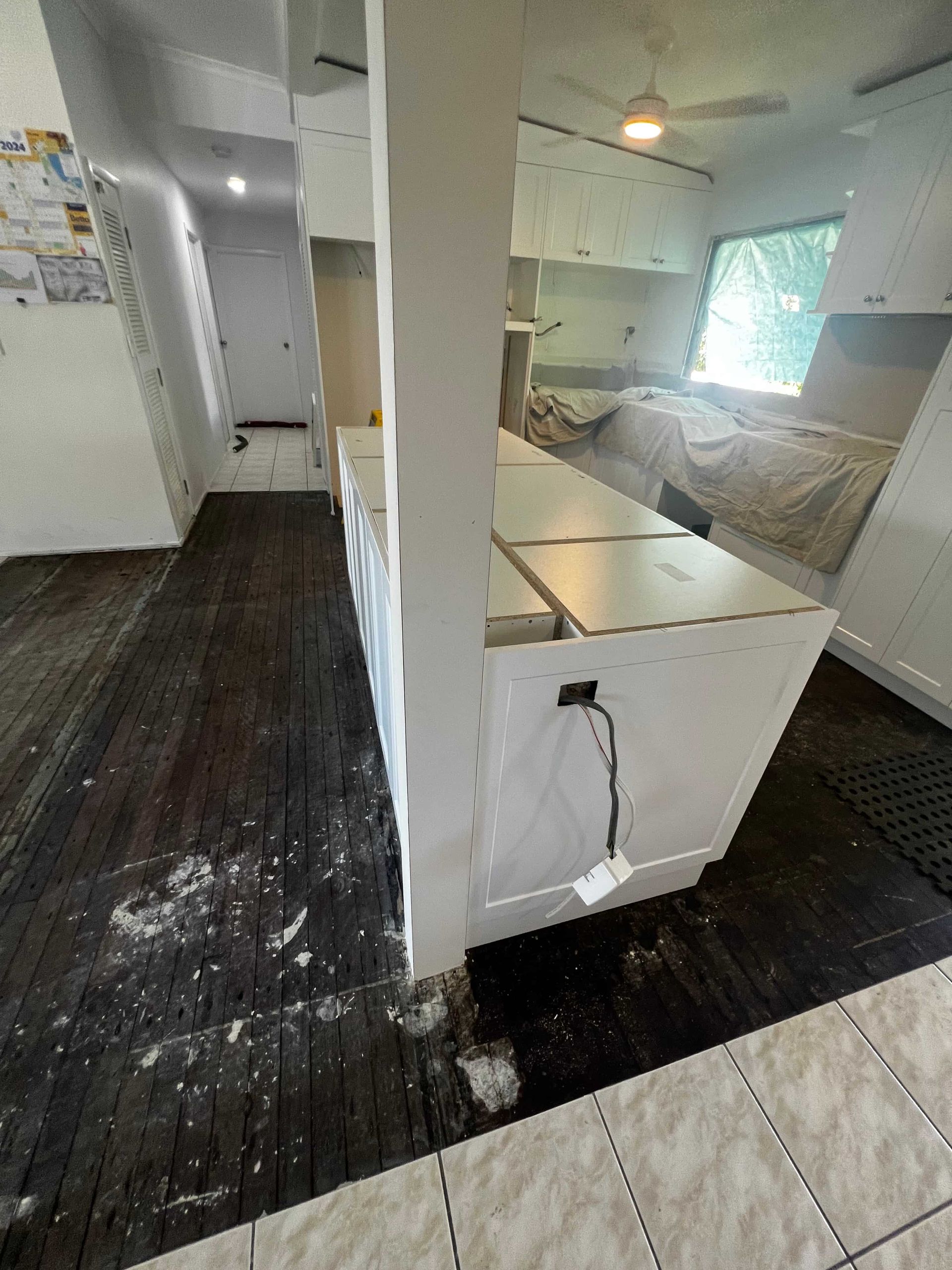 A Kitchen With a Bed and a Washer and Dryer in It — Poljak Plasterers in North Ward, QLD