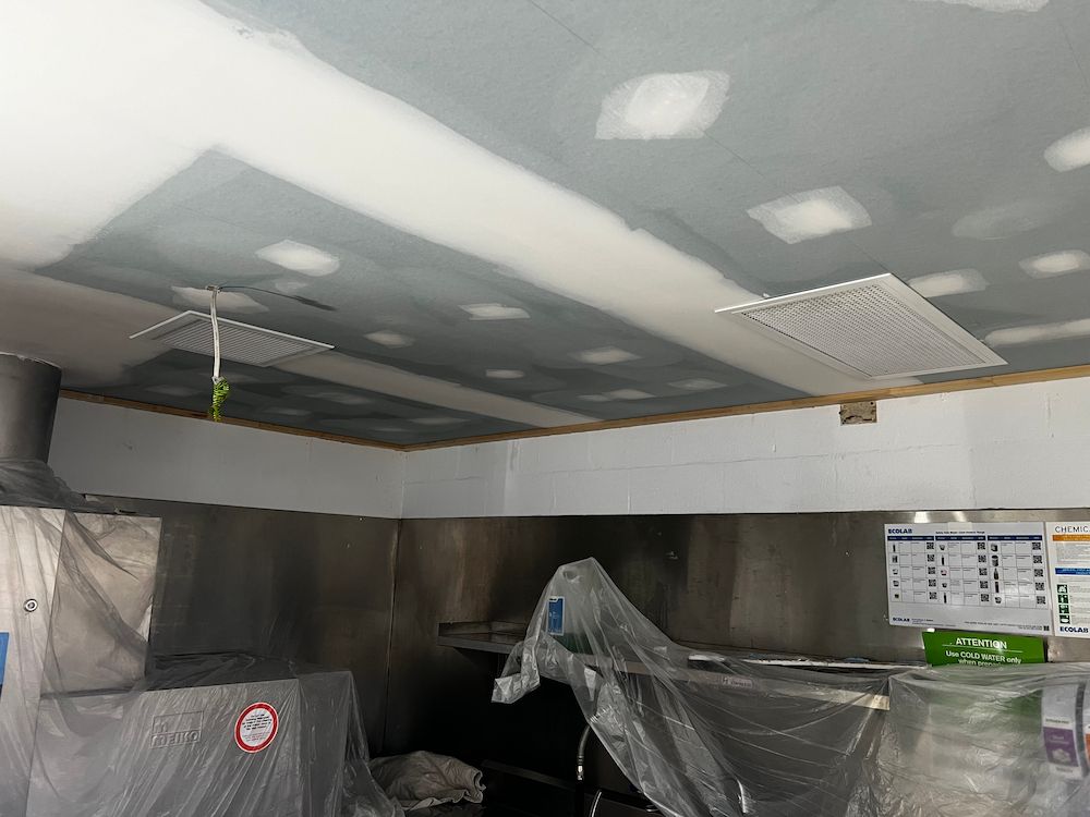 A Kitchen With a Ceiling That is Covered in Plastic — Poljak Plasterers in Alligator Creek, QLD