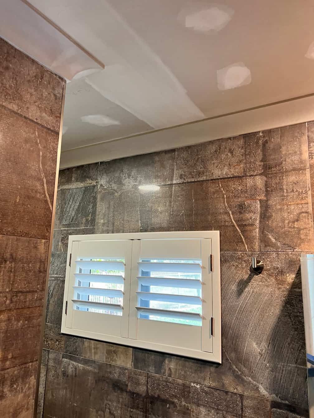 A Bathroom With a Mirror and a Window With Shutters — Poljak Plasterers in Annandale, QLD
