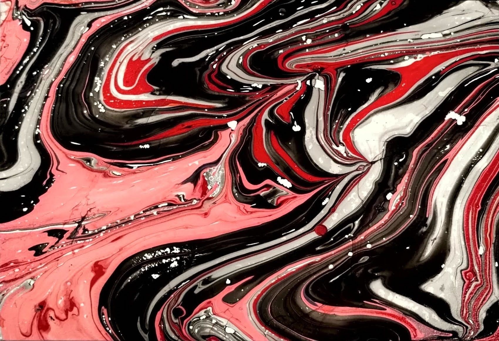 A close up of a red , black and white marble texture.