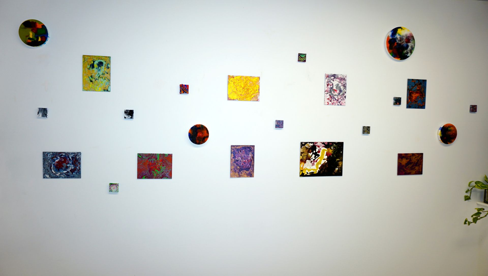 A white wall with a bunch of paintings on it