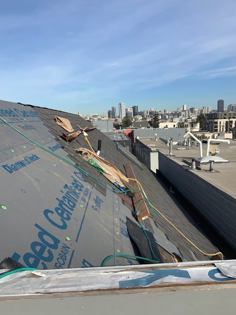A roof with a lot of wires on it and a city in the background.