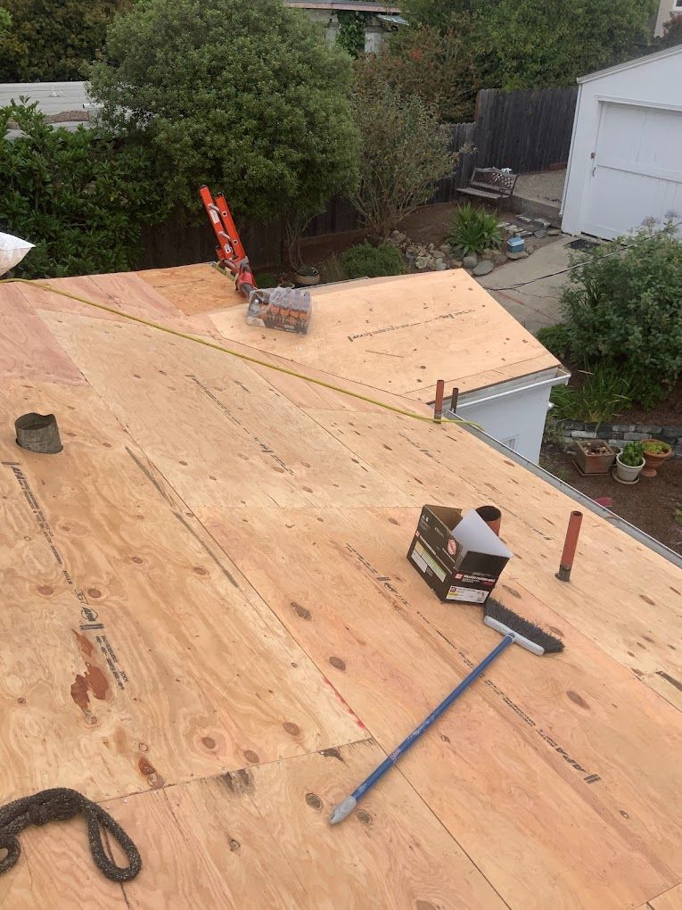 A broom is sitting on top of a wooden roof.
