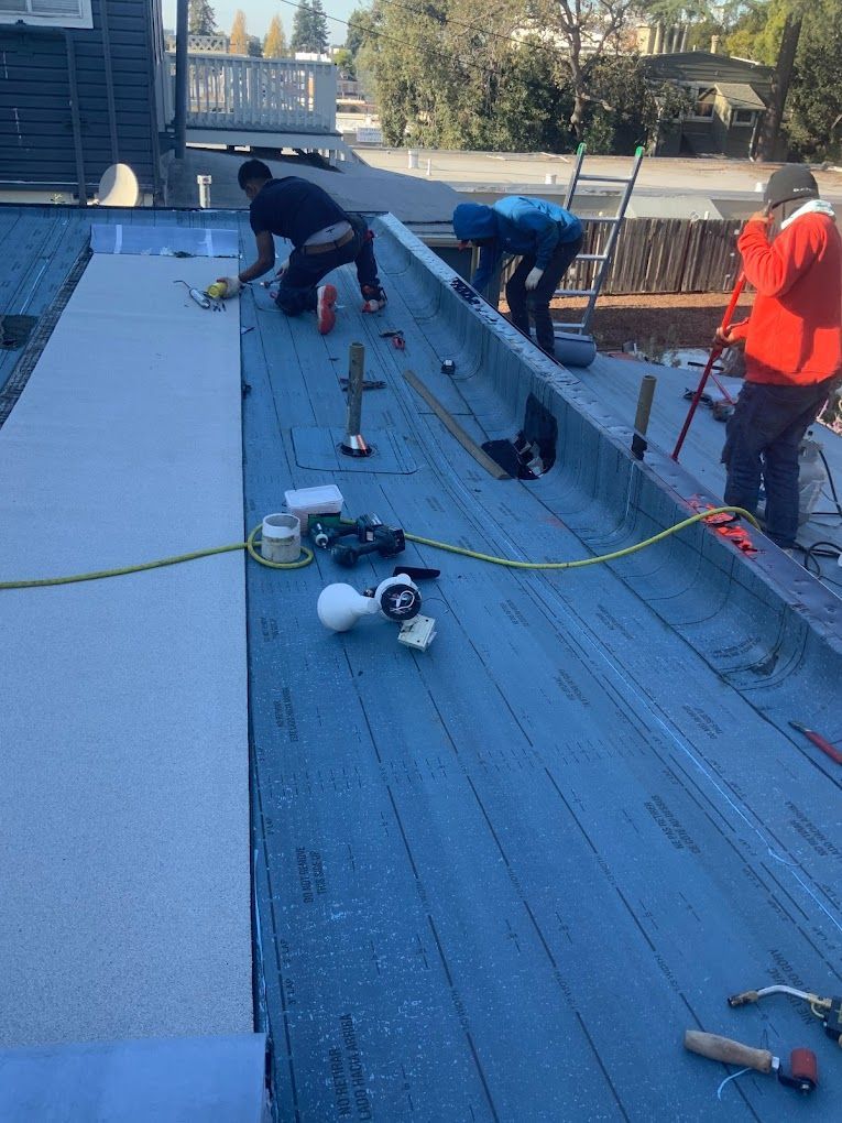 A group of men are working on a roof.