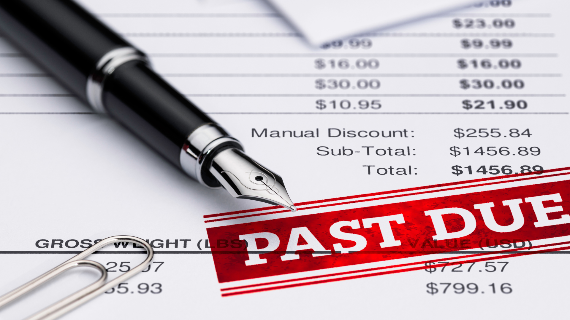 A pen is sitting on top of a receipt that says past due